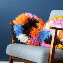 Molla Mills Loimu Rya Cushion is crocheted with Lankava Lysti yarn using colors Snow 851, Marigold 878, Summer sky 857, Desert rose 872, Cotton candy 871, Coffee 868 and Dandelion 864.