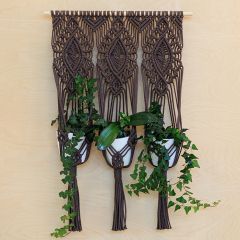Brown macramé Ornament Wall Plant Hanger hanging on a wall with three plants. Made with Lankava Paulina Chunky Twine in the colour Cocoa 55.