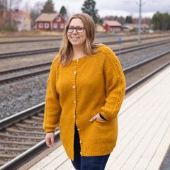 Aino-villatakki naisen yllä. Villatakki neulotaan Lankavan Mainio-sukkalangasta värillä Curry 665.