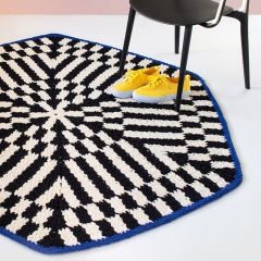 Ilmainen käsityöohje: Birka-matto. Kuvassa Molla Millsin suunnittelema mustavalkoinen matto, jonka päällä keltainen kenkäpari ja musta tuoli.
