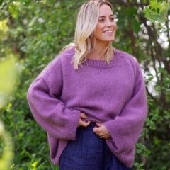 IINA-paita näyttelijä Iina Kuustosen yllä. Paita on neulottu Lankava Helli -merinolangasta sävyssä 351 Kanerva ja Austermann Kid Silk -langasta sävyssä 24 Malva.