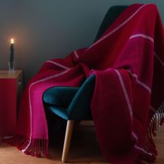 Jouluraita-huopa nojatuolin päällä. Huopa kudotaan Esito-huopalangasta väreissä tummanpunainen (7021), syklaaminpunainen (7013), punainen (7022) ja valkaistu (7001).