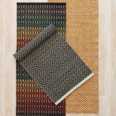 Kudotut Ornamentti-, Palkki- ja Väre-matot lattialla.