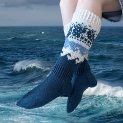 Oulu-laiva sukat naisen jalassa merimaisemassa. Sukat on neulottu Lankavan Lysti-sukkalangasta väreillä Lumi (851), Sade (856) ja Kesätaivas (857).