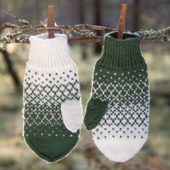 Peilikuva-lapaset oksalle ripustettuina. Lapaset neulotaan Istex Kambgarn -langasta väreillä valkoinen 51 ja vihreä 0945.