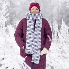 Puffy-kaulahuivi mallin päällä talvisessa maisemassa. Huivi sormineulotaan Alize Puffy Color -langasta värillä Lakritsijäätelö 5925.
