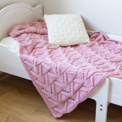 Aura-torkkupeitto lasten sängyllä. Torkkupeitto neulotaan Alize Superlana Maxi -langasta värillä puuteriroosa 161.