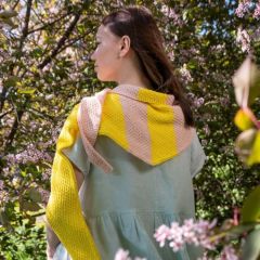 Kesä-kolmiohuivi naisen yllä. Huivi neulotaan Alize Cotton Gold -langasta väreillä kirkas keltainen 110 ja puuteriroosa 393.