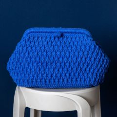 Paanu bag on a chair. The bag is crocheted with Lankava Moi Braided Yarn using color blue 83.