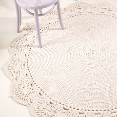 Free pattern: Lace edged rug on the floor under a chair. The rug is crocheted with Lilli Tube Yarn using colour natural white 2.